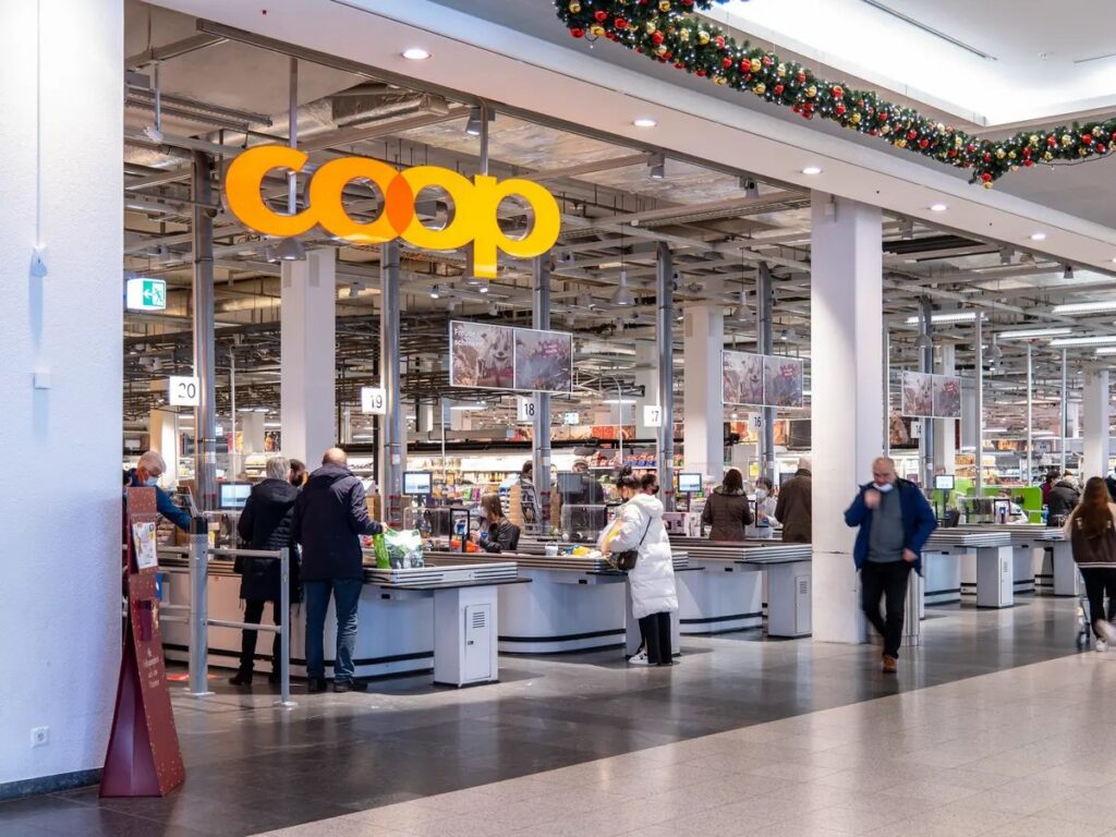 Collaboratrice d'un magasin Coop renseignant une cliente