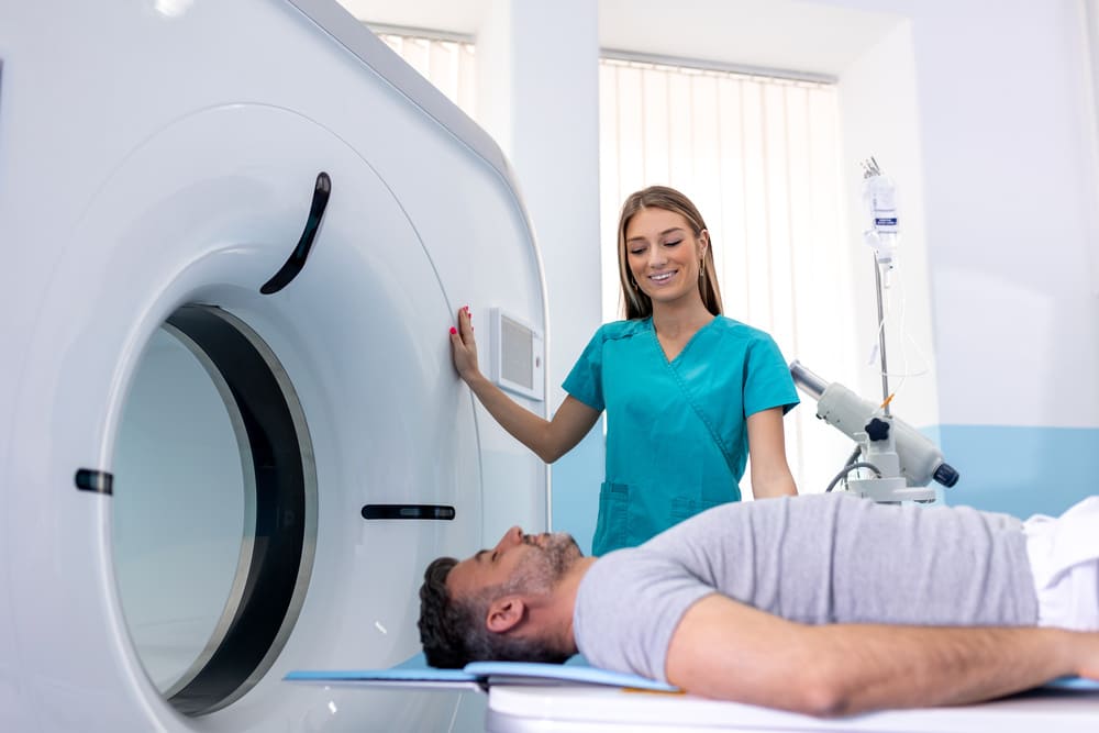 Manipulateur en électroradiologie installant un patient dans un scanner d'un centre d'imagerie