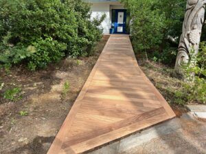 Chemin stabilisé en gravier longeant la façade d'une maison, avec bordure nette et bande drainante au pied du mur